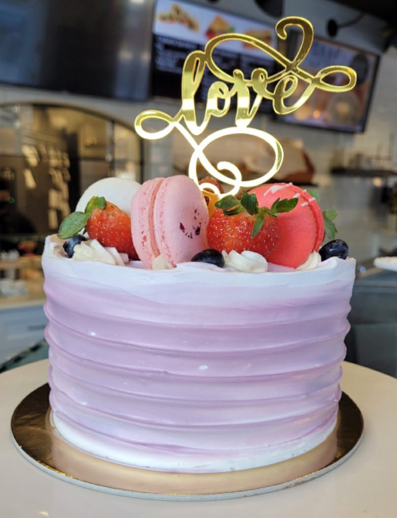 Cake Topped with Extra Macarons and a Love Topper